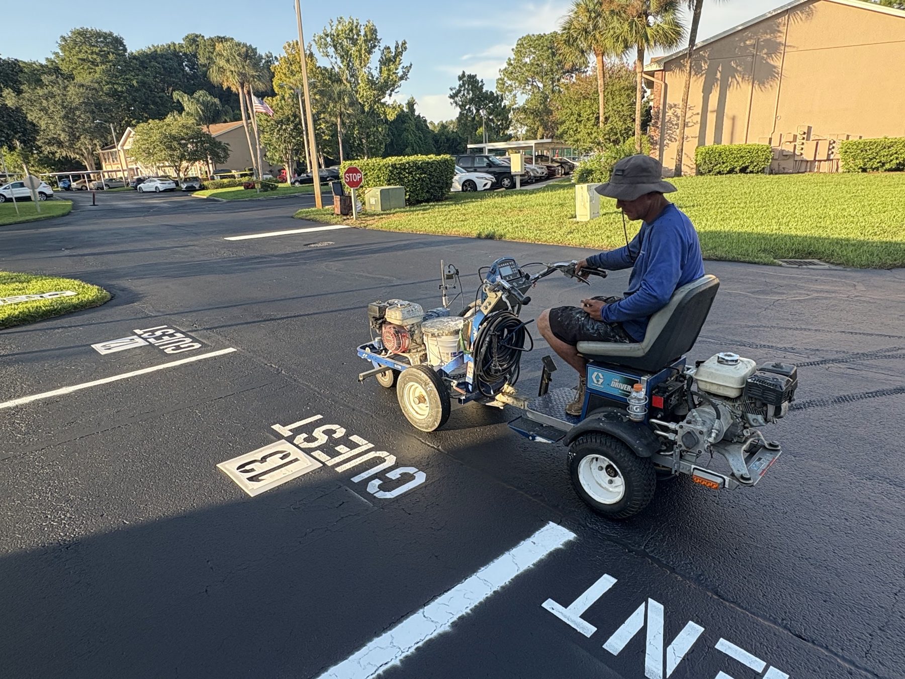 Tar Seal crew member striping a parking lot with a line striping machine