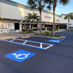 Blue ADA accessible parking stall freshly striped on new black sealcoat