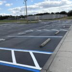 Fresh sealcoat with white striping, blue ADA lines and wheel stops